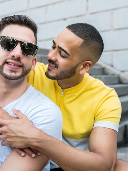 Couple d'hommes enlacés sur des marches